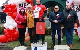 Wsp&oacute;lne zdjęcie zwycięzc&oacute;w biegu w poszczeg&oacute;lnych kategoriach wiekowych z organizatorami wydarzenia