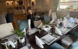 Uczennica w restauracji hotelu nakrywa do stołu