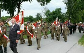 Przemarsz poczt&oacute;w sztandarowych ulicami Oleszna do kościoła parafialnego