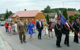 Przemarsz poczt&oacute;w sztandarowych i zaproszonych gości ulicami Oleszna do kościoła parafialnego