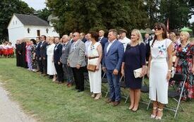Uczestnicy dożynek stoją na baczność podczas odegrania Hymnu Polski