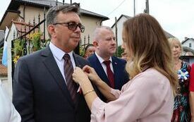 Pracownica Starostwa przypina kotylion Staroście Włoszczowskiemu