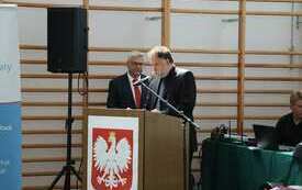 Przy m&oacute;wnicy jeden z prowadzących uroczystość. za nim dyrektor Zespołu Sk&oacute;ł nr 2 we Włoszczowie