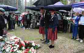 Składanie kwiat&oacute;w pod pomnikiem.