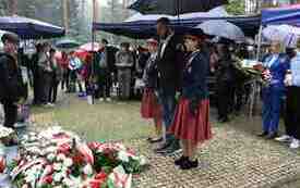 Składanie kwiat&oacute;w pod pomnikiem.