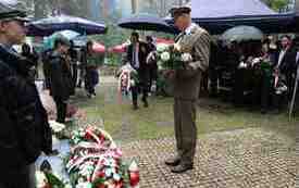 Składanie kwiat&oacute;w pod pomnikiem.