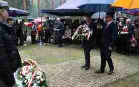 Składanie kwiat&oacute;w pod pomnikiem.