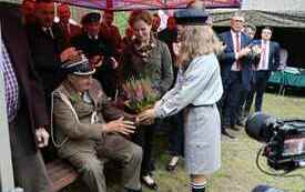 Harcerka podaje wrzos kombatantowi.