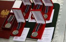 Na niebieskim suknie pudełka z odznaczeniami.