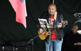 Muzyk przy pulpicie z nutami gra na gitarze.