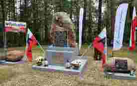 Kamienny obelisk na Pękowcu udekorowany flagami narodowymi