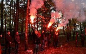 Trzy osoby trzymają odpalone race