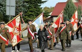 Uczestnicy uroczystości maszerują z cmentarza do Kościoła w Olesznie