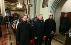 Uczestnicy uroczystości zgromadzeni na mszy świętej w kościele. Na pierwszym planie Członek Zarządu Powiatu Włoszczowskiego, Burmistrz Gminy Włoszczowa i Przewodniczący Rady Miejskiej we Włoszczowie