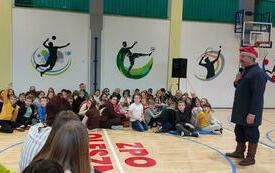 Laureaci konkursu, organizatorzy i zaproszeni goście wysłuchują kwatermistrza Grupy Rekonstrukcji Historycznych Grzegorza Szymańskiego