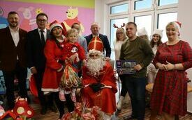 Wsp&oacute;lne zdjęcie obdarowanego dziecka ze świętym Mikolajem i jego pomocnikami
