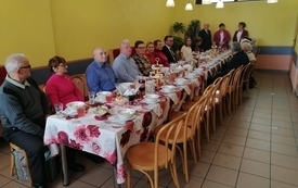 Uczestnicy spotkania siedzą przy stołach
