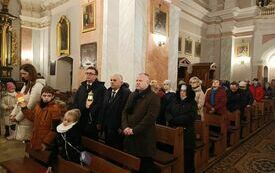 Uczestnicy mszy stoją w ławkach. Na pierwszym planie starosta, wicestarosta i przewodniczący Rady Powiatu