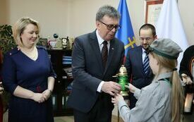 Harcerka przekazuje zapaloną świeczkę staroście