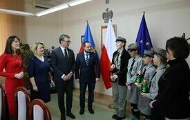 Opiekunka harcerek opowiada zgromadzonym w gabinecie Starosty o Betlejemskim Świetle Pokoju