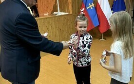 Dzieciom zostają rozdane cukierki