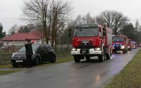 Samochody strażackie jadą ulicą do remizy w Chotowie