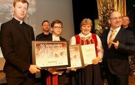 Dyrektor DK Włoszczowa i ksiądz z włoszczowskiej parafii wręczają nagrodę przedstawicielkom jednego z nagrodzonych zespoł&oacute;w