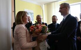 Jeden z pracownik&oacute;w urzedu wręcza dyrektorce bukiet kwiat&oacute;w od załogi