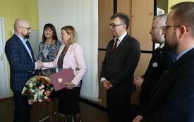Sekretarz wręcza bukiet kwiat&oacute;w dyrektor Powiatowego urzędu Pracy we Włoszczowie  