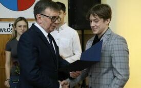 Starosta wręcza stypendium sportowe jednemu z wyr&oacute;żnionych uczni&oacute;w
