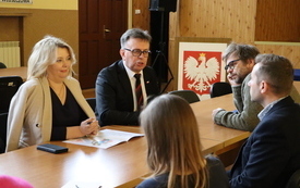 Przy stole siedzą przedstawiciele Zarządu Powiatu i organizator&oacute;w Targ&oacute;w Edukacyjnych. 