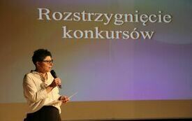 Nauczycielka przedstawia wyniki konkursu plastycznego