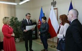 Starosta wręcza voucher przedstawicielce KGW, kt&oacute;re zajęło trzecie miejsce w konkursie