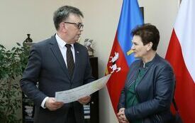 Starosta wręcza voucher przedstawicielce KGW, kt&oacute;re zajęło trzecie miejsce w konkursie