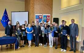 Uczestnicy inauguracyjnej sesji stoją wraz z Zarządem Powiatu pozując do pamiątkowego zdjecia