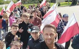 Dzieci z Oleszna trzymają w rękach flagi Polski