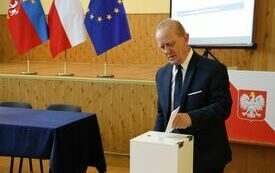 Radni kolejno wrzucają do urny wyborczej karty do głosowania na starostę