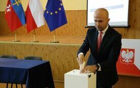 Radni kolejno wrzucają do urny wyborczej karty do głosowania na starostę