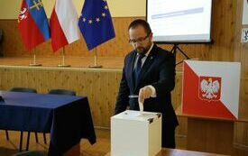 Radni kolejno wrzucają do urny wyborczej karty do głosowania na starostę