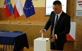 Radni kolejno wrzucają do urny wyborczej karty do głosowania na starostę
