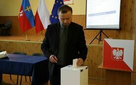 Radni kolejno wrzucają do urny wyborczej karty do głosowania na starostę