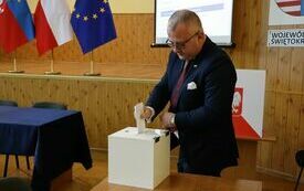 Radni kolejno wrzucają do urny wyborczej karty do głosowania na starostę