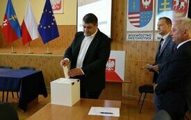Radni kolejno wrzucają do urny wyborczej karty do głosowania na starostę
