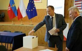Radni kolejno wrzucają do urny wyborczej karty do głosowania na starostę