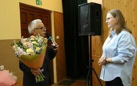 Najstarszy Radny Zbigniew Matyśkiewicz wręcza Przewodniczącej Powiatowej Komisji Wyborczej we Włoszczowie bukiet kwiat&oacute;w