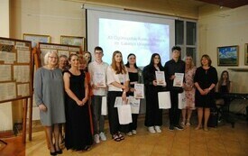 Laureaci konkursu wraz z organizatorami i gośćmi pozują do pamiątkowej fotografii.