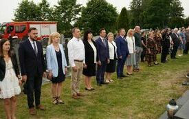 Uczestnicy uroczystości stoją na baczność na cmentarzu
