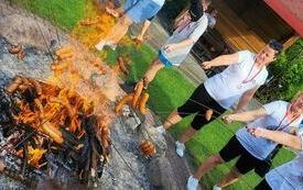 Uczestniczki Olimpiady pieką kiełbaski na ognisku