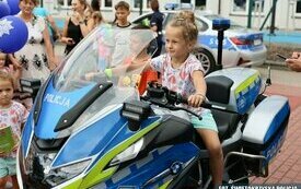 Dziewczynka na policyjnym motorze pozuje do zdjęcia