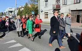 Uczestnicy uroczystości maszerują ulicą Partyzant&oacute;w z kościoła do szkoły